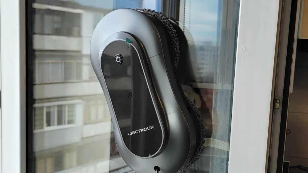 Robot lave-vitre Liectroux YW810 en fonctionnement sur une fenêtre, nettoyant efficacement les vitres d’un appartement en hauteur.