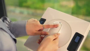 Utilisateur appuyant sur le bouton d’un robot lave-vitre