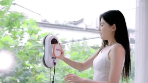 Personne utilisant un robot lave-vitre sur une fenêtre