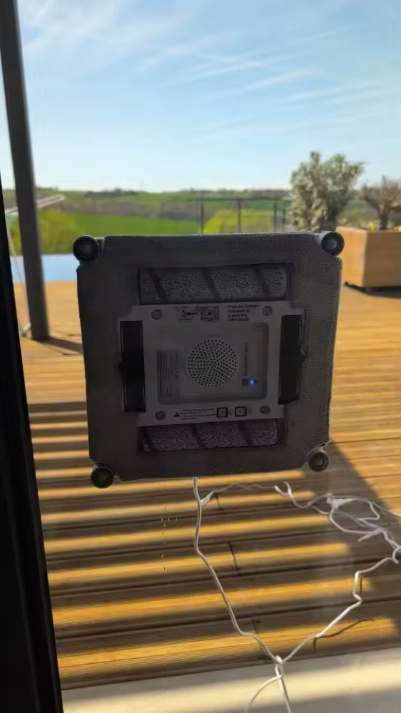 Gros plan du Liectroux S9 et de sa lingette microfibre en action sur une baie vitrée