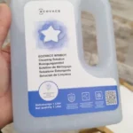 Flacon de solution de nettoyage Ecovacs Winbot 1 L tenu en main par un acheteur